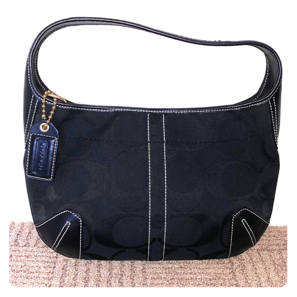 Black shoulder bag with classic Coach pattern.